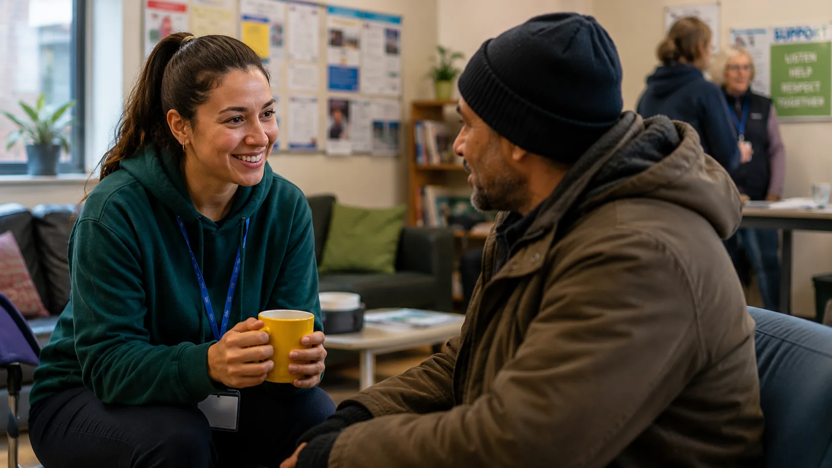 Charity support worker in conversation with a service user in a community setting